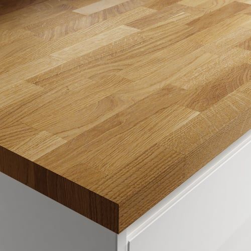 Wooden butcher block countertop on a white cabinet.
