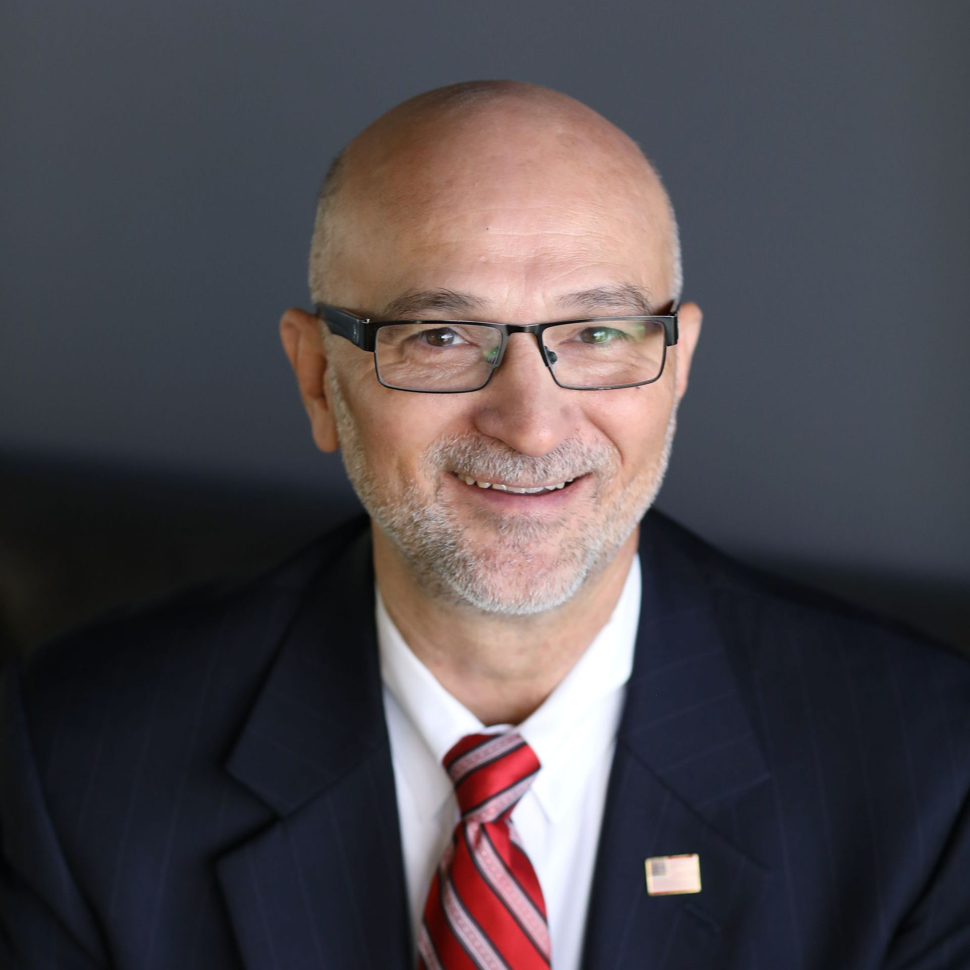 A man in a suit and tie is smiling for the camera