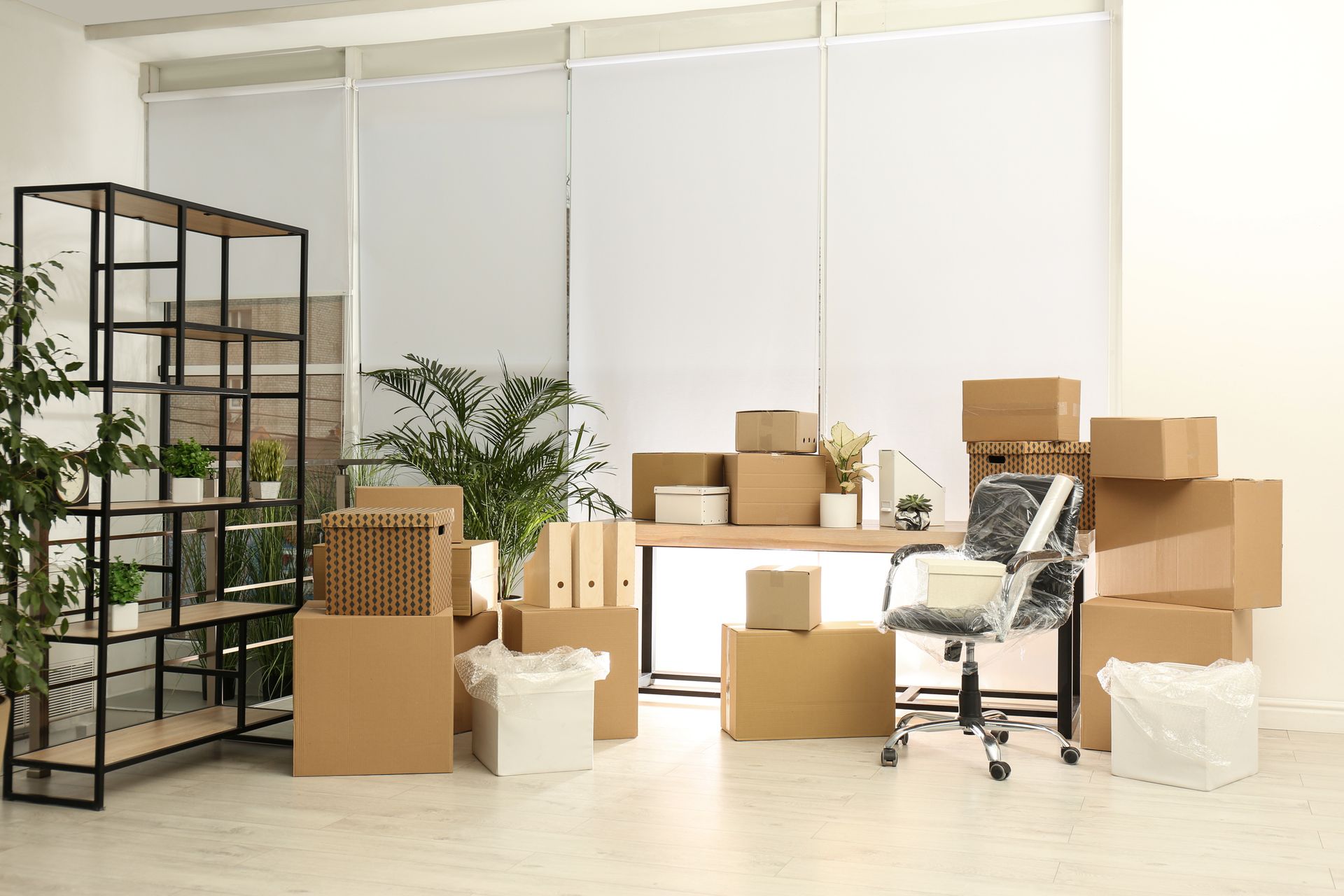 A room filled with lots of cardboard boxes and a desk.