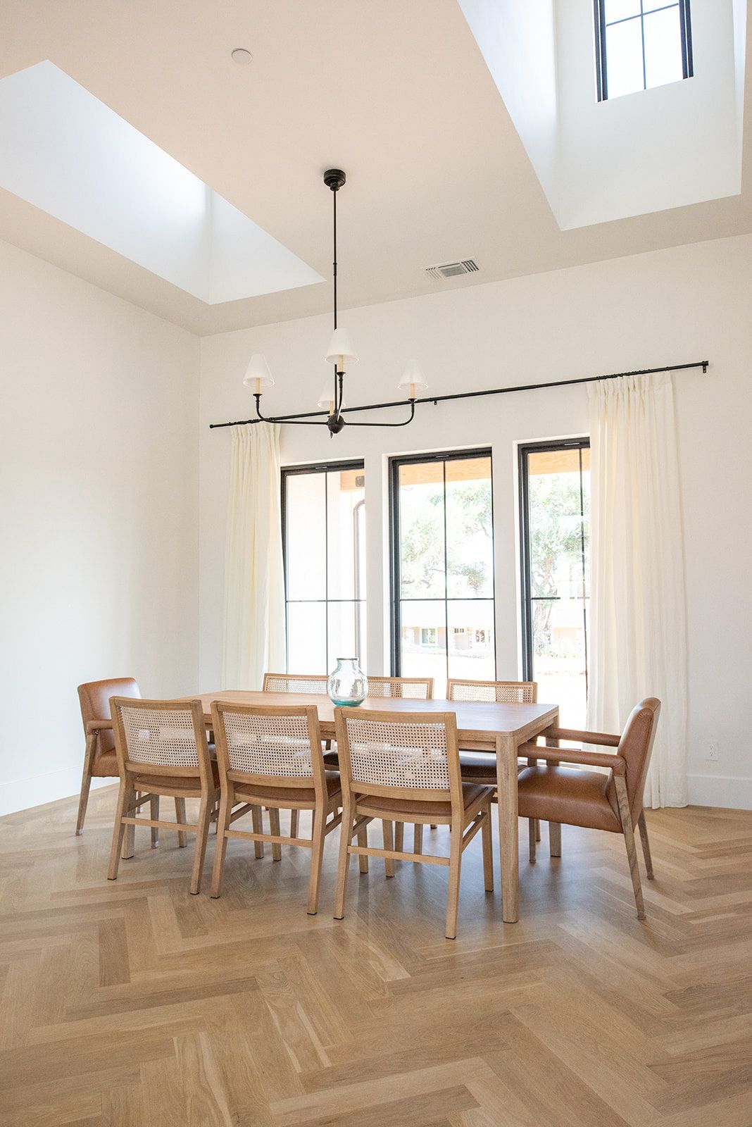 a dining room with a table and chairs and a skylight .