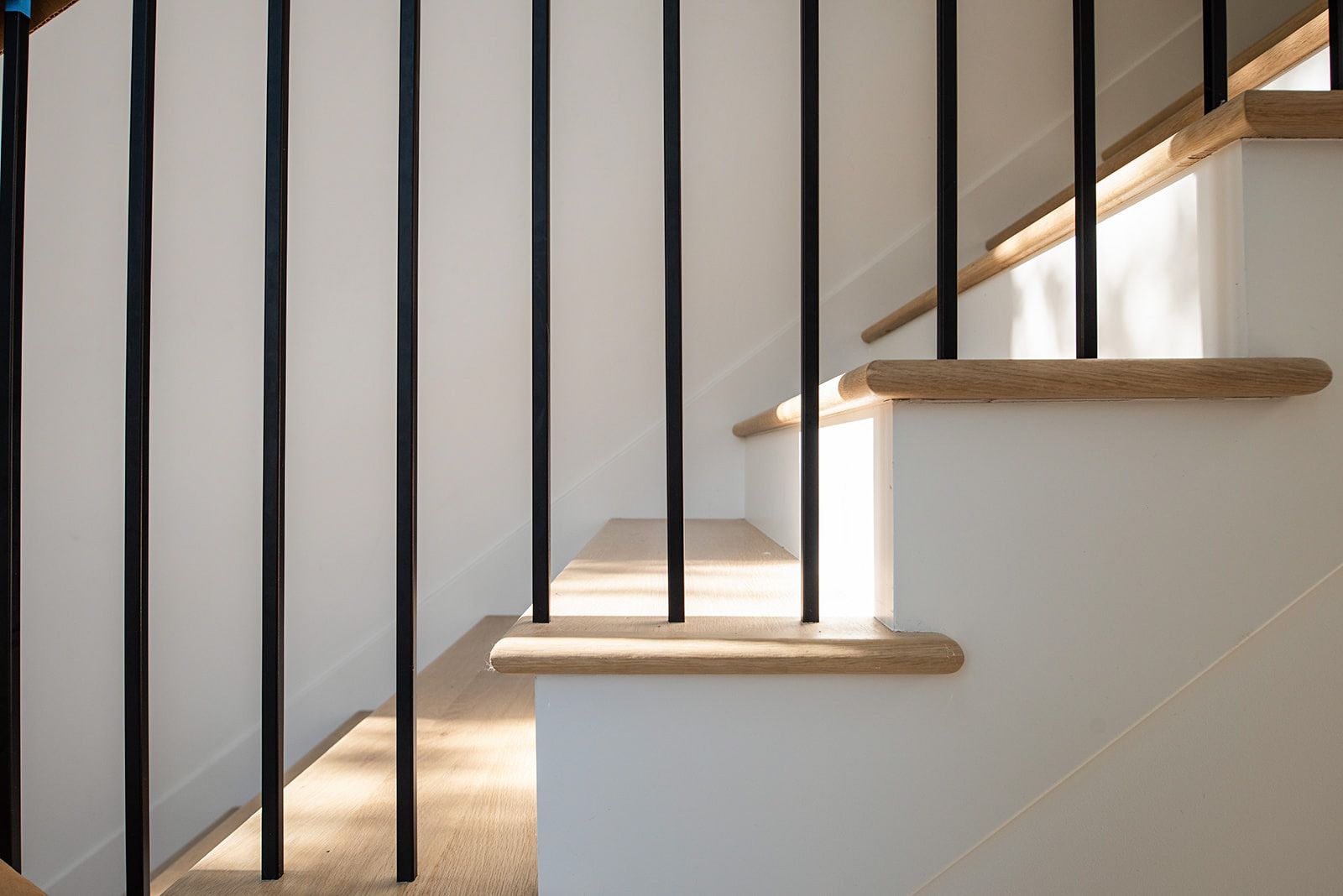the stairs are made of wood and metal and have a black railing .