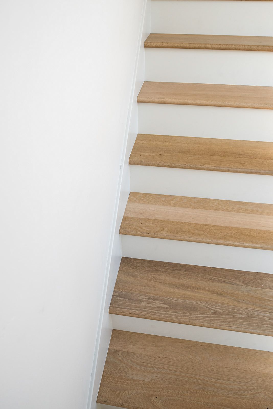 a close up of a set of wooden stairs with white steps .