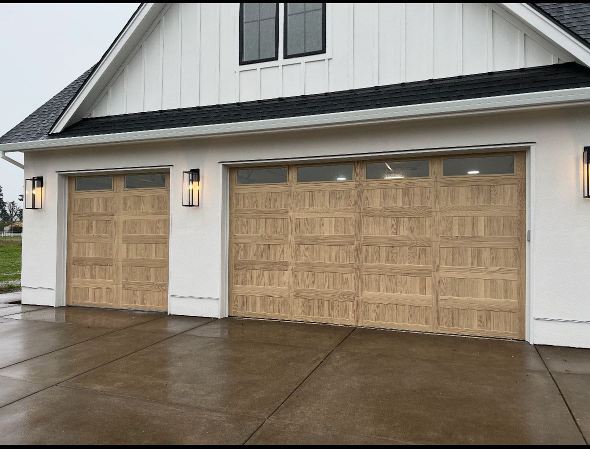 A pair of brown garage doors with windows on the side of a building.