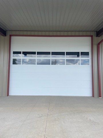 A white garage door with a lot of windows in a garage.