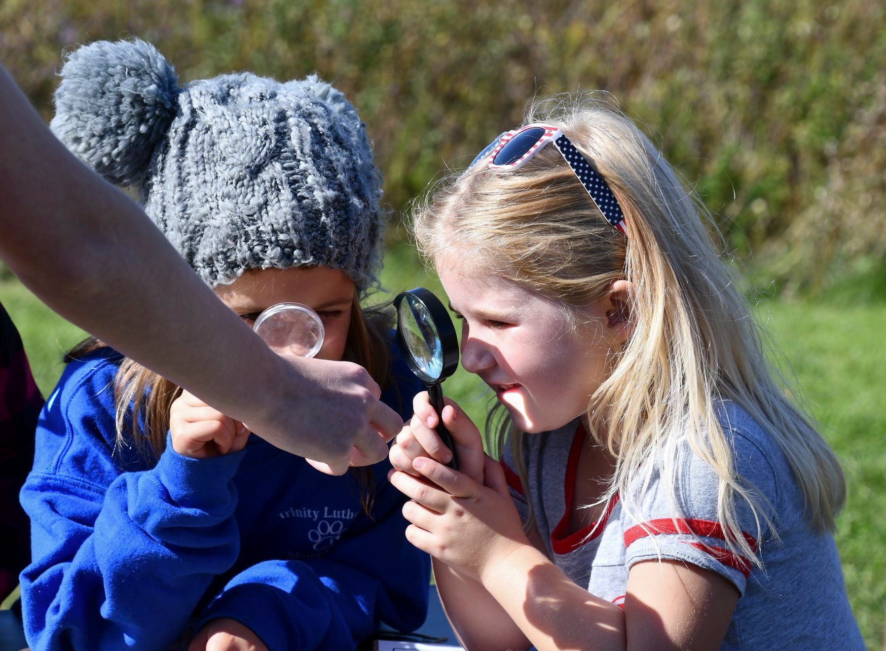Young students looking through a magnifying glass