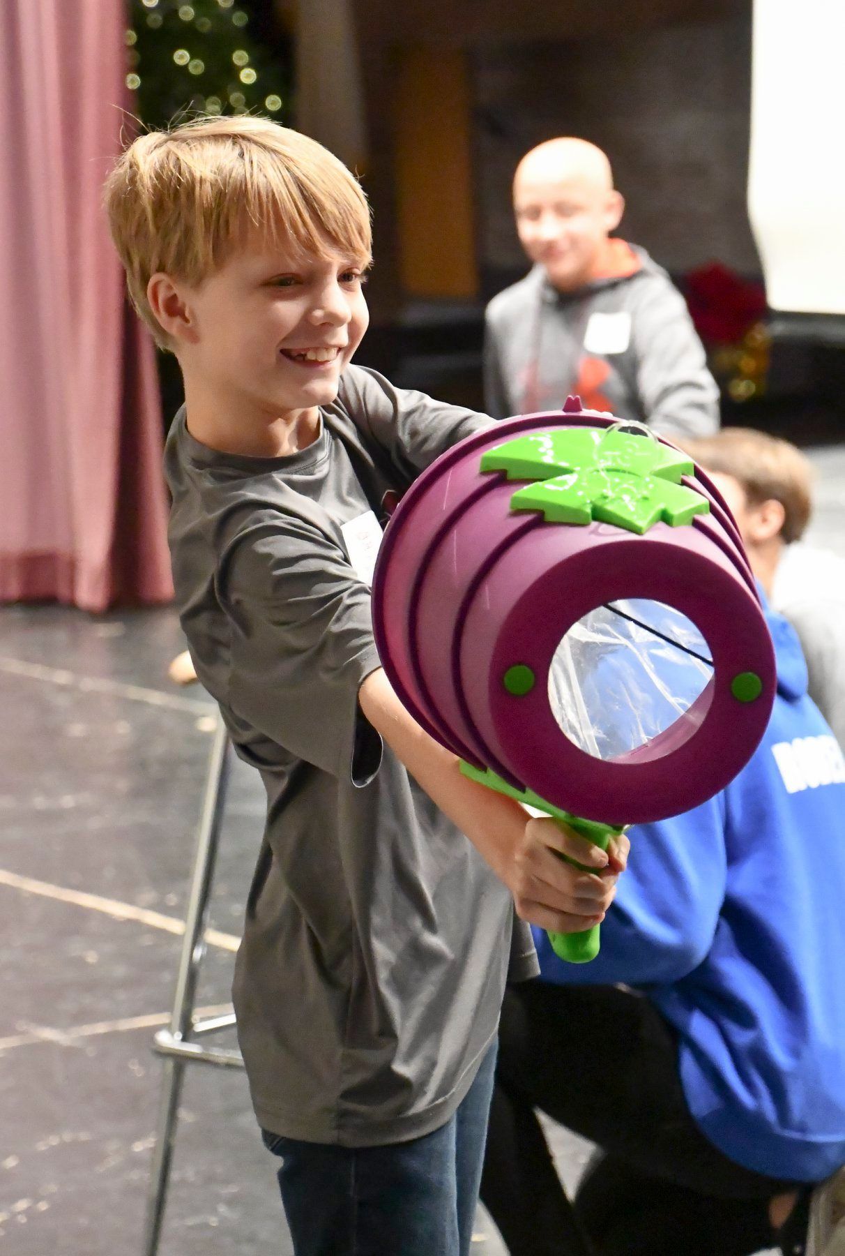 Boy takes careful aim to topple plastic cups with some air at the high school