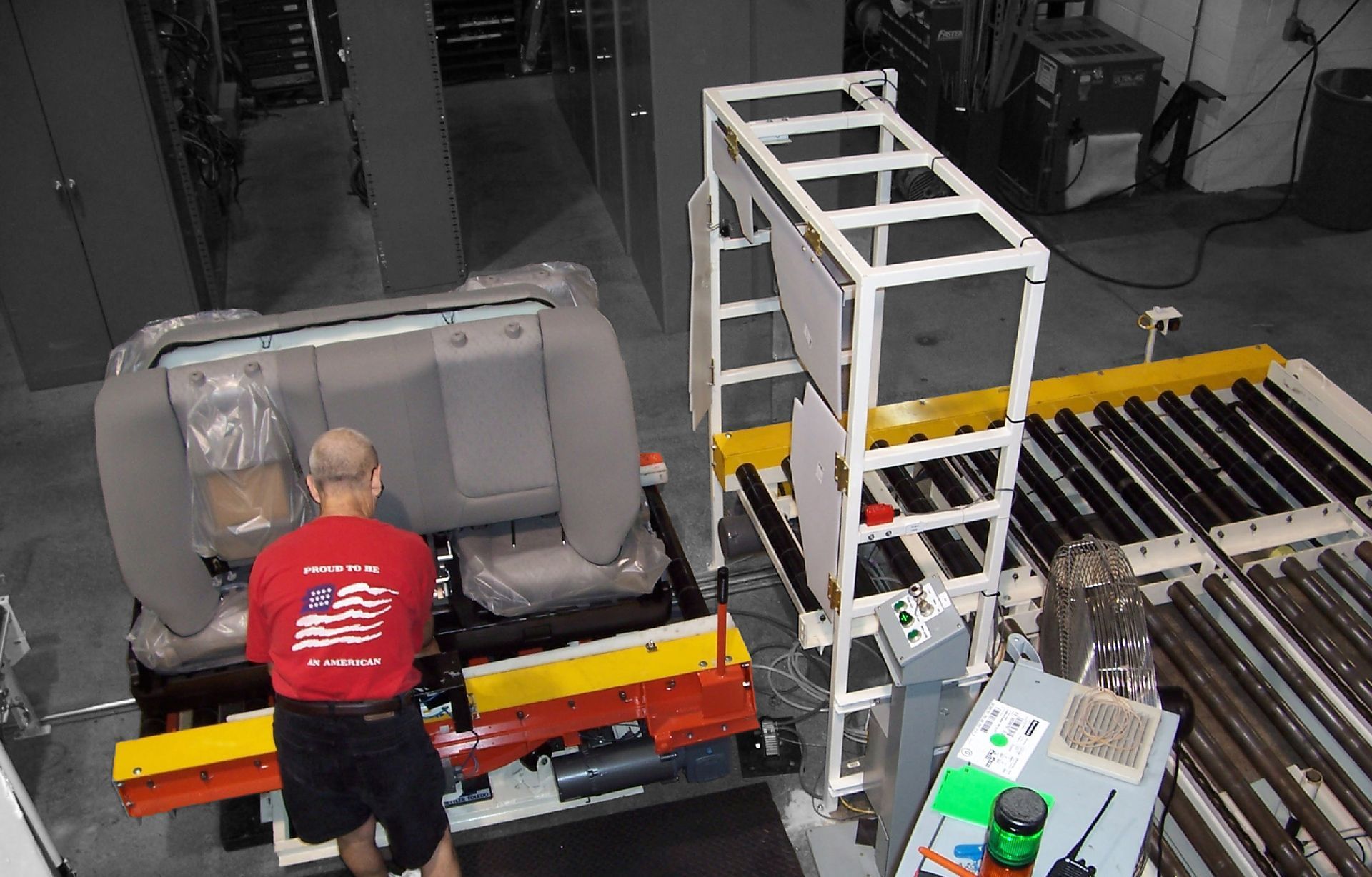 A man in a red shirt is working on a car seat 