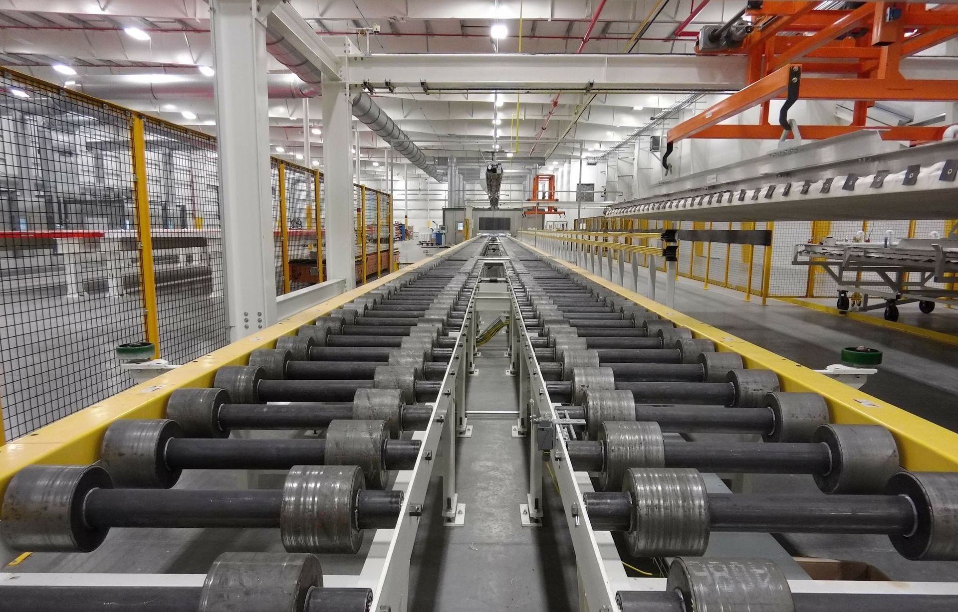 A conveyor belt is sending heavy units through a large warehouse.