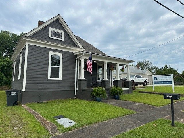 A small house with an american flag on the porch.