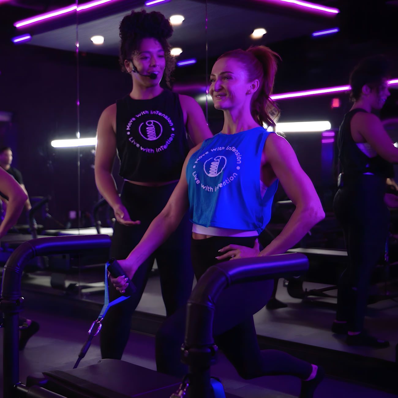 A woman in a blue tank top is running on a treadmill