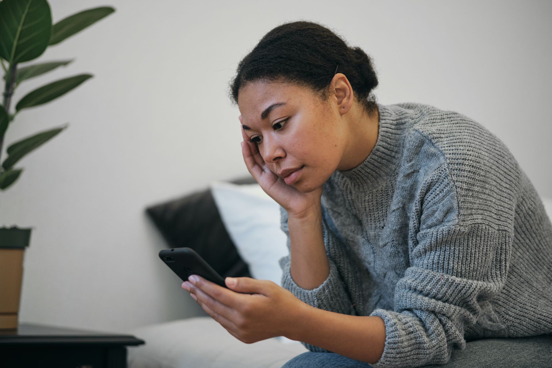 A person is using a calculator while writing in a notebook.