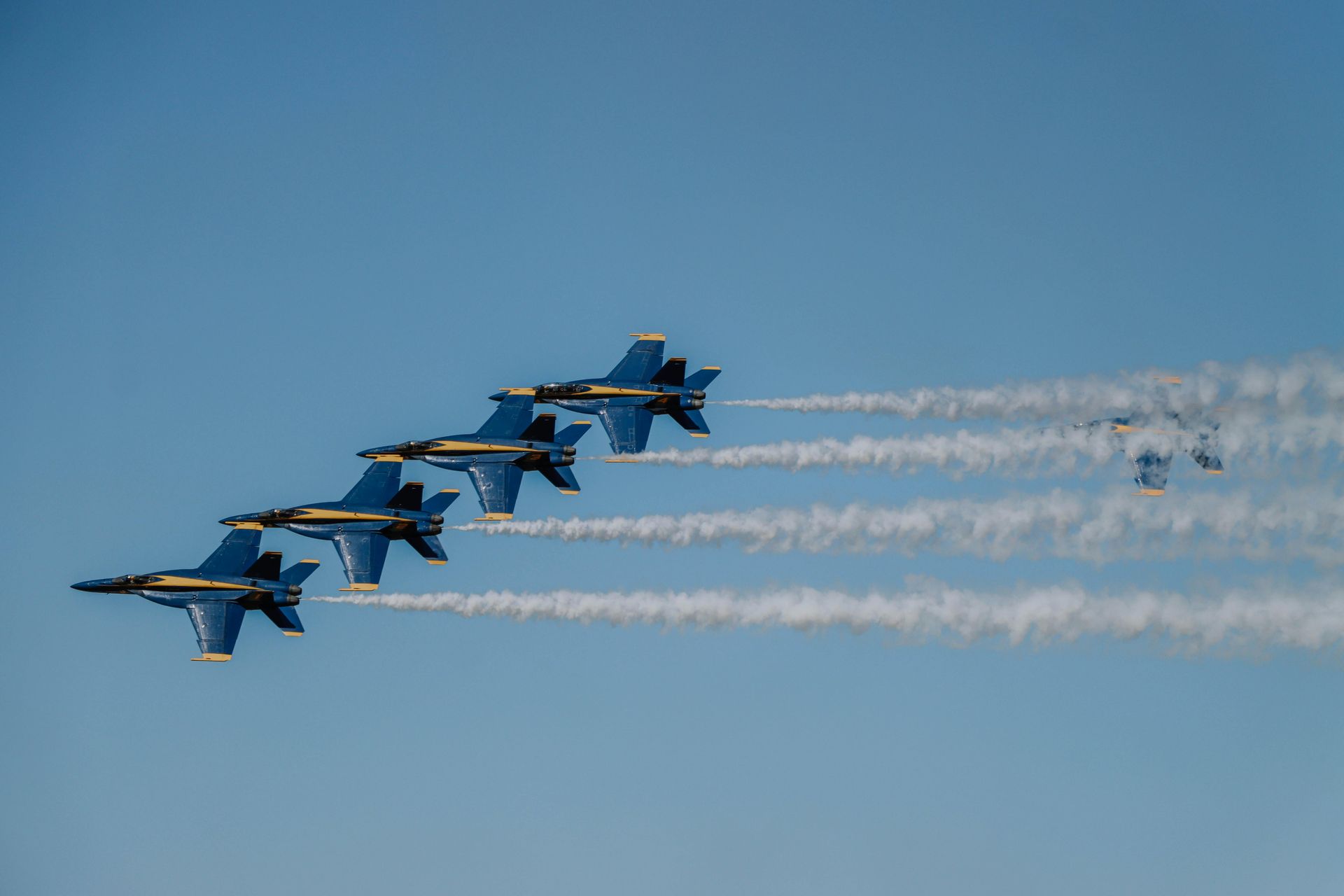 Four fighter jets in tight formation against a cloudy sky