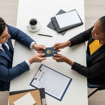 A man is giving a passport to a woman at a table.