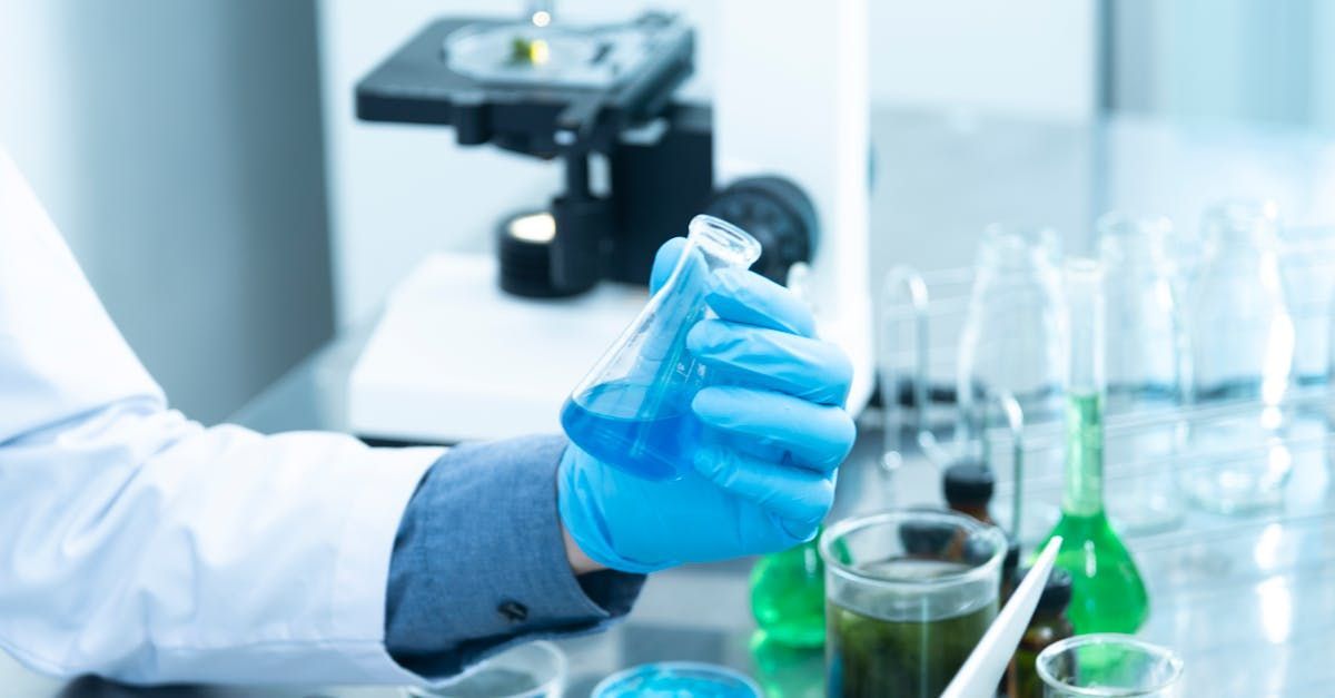 A scientist is pouring liquid into a beaker in a laboratory.