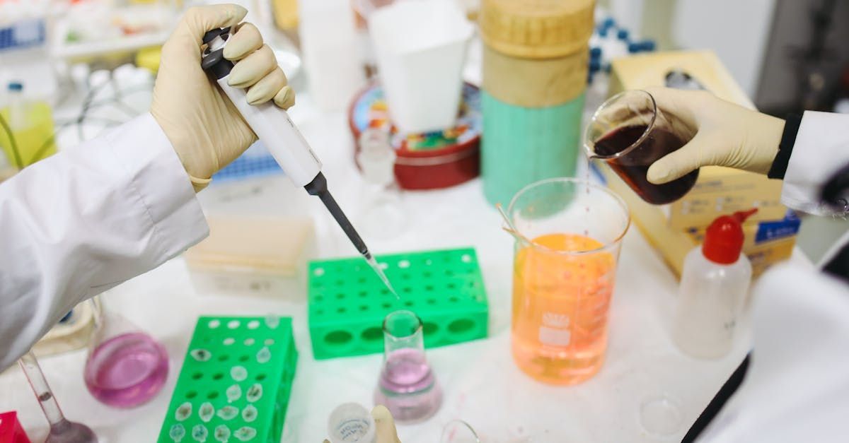 A scientist is using a pipette to pour liquid into a beaker.