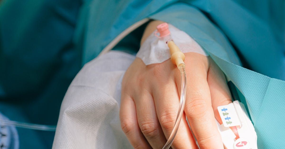 A close up of a person 's hand with an iv in it.