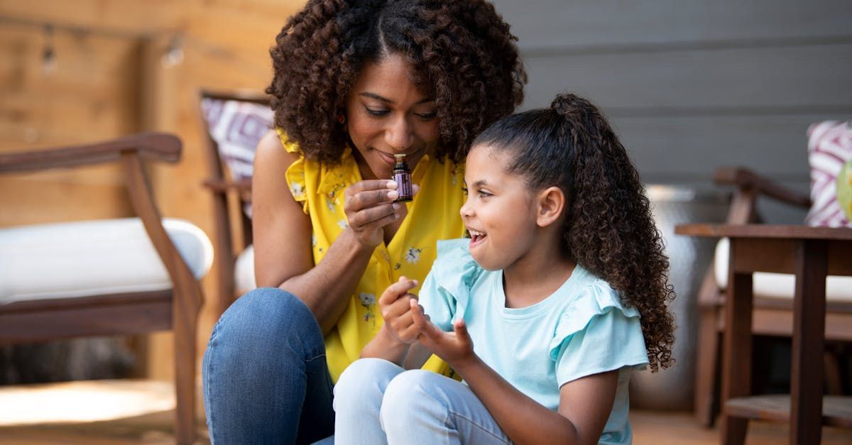 A woman and a little girl are sitting on the floor.