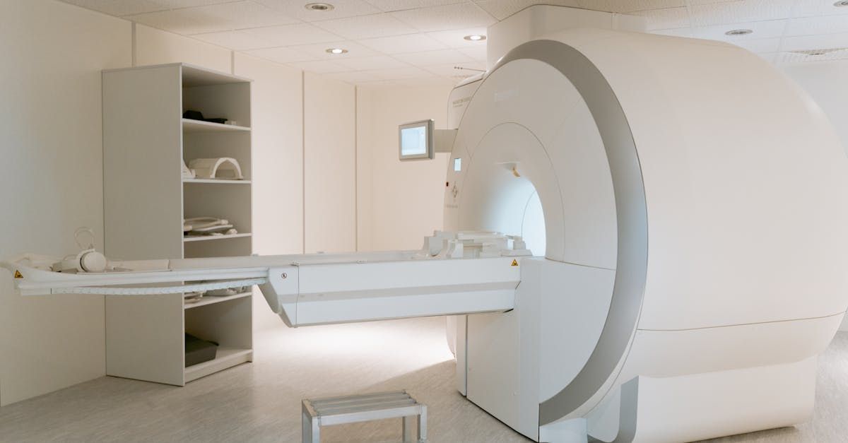 A mri machine is sitting in a white room.