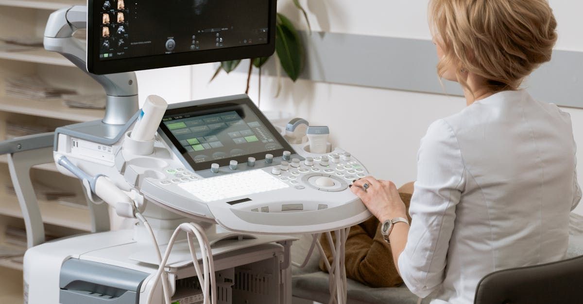 A woman is using an ultrasound machine in a hospital.