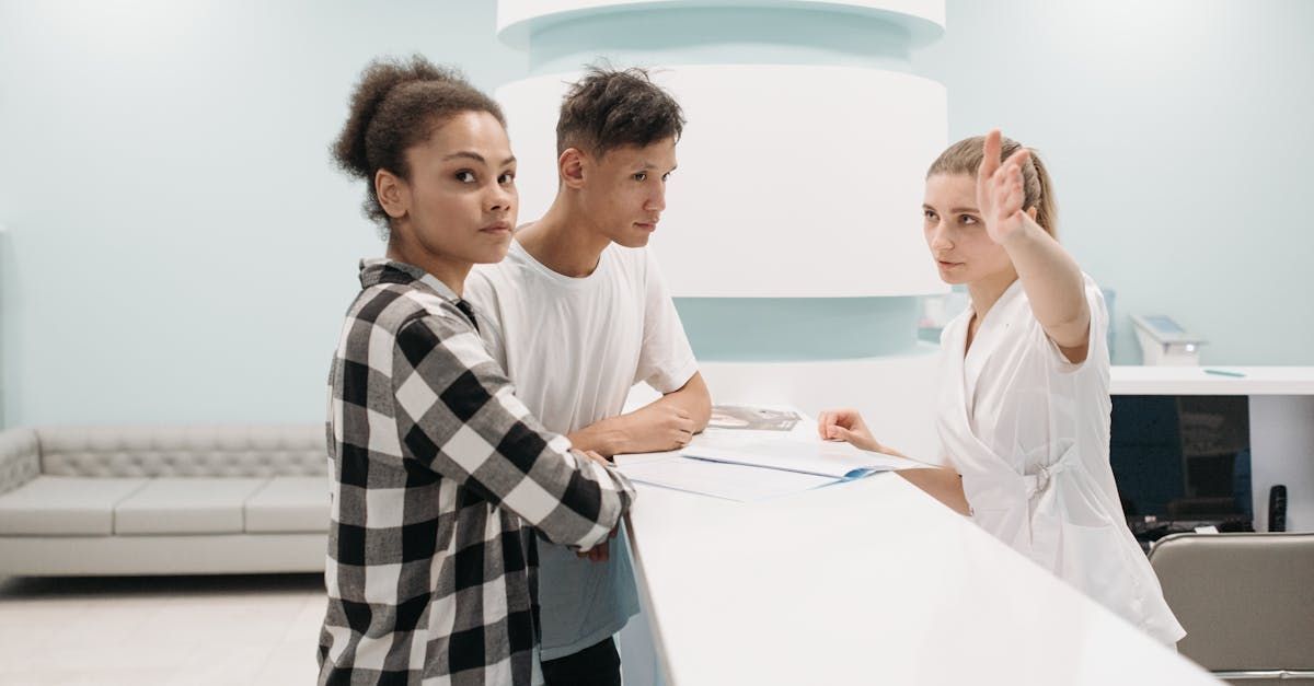 A woman and a boy are standing at a counter in a hospital.