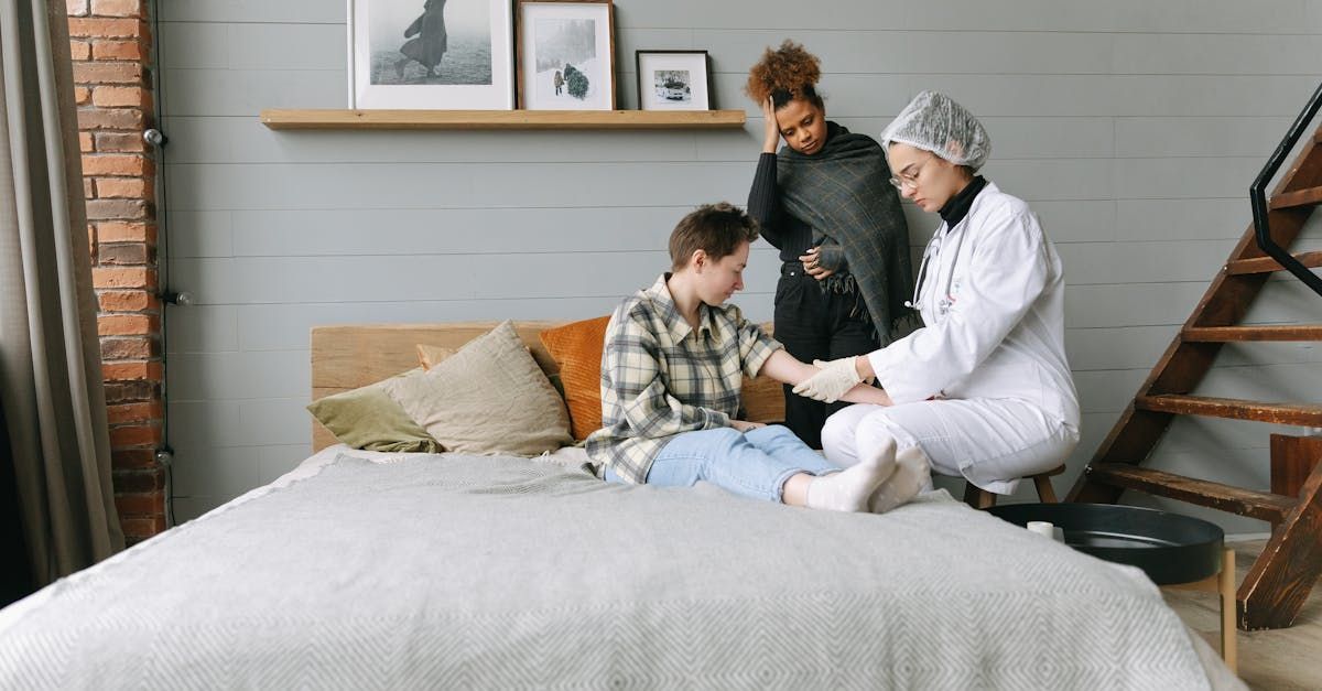 A doctor is sitting on a bed with a patient.