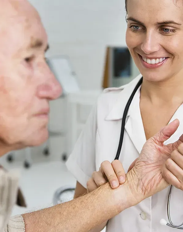 a nurse is taking the pulse of an elderly man