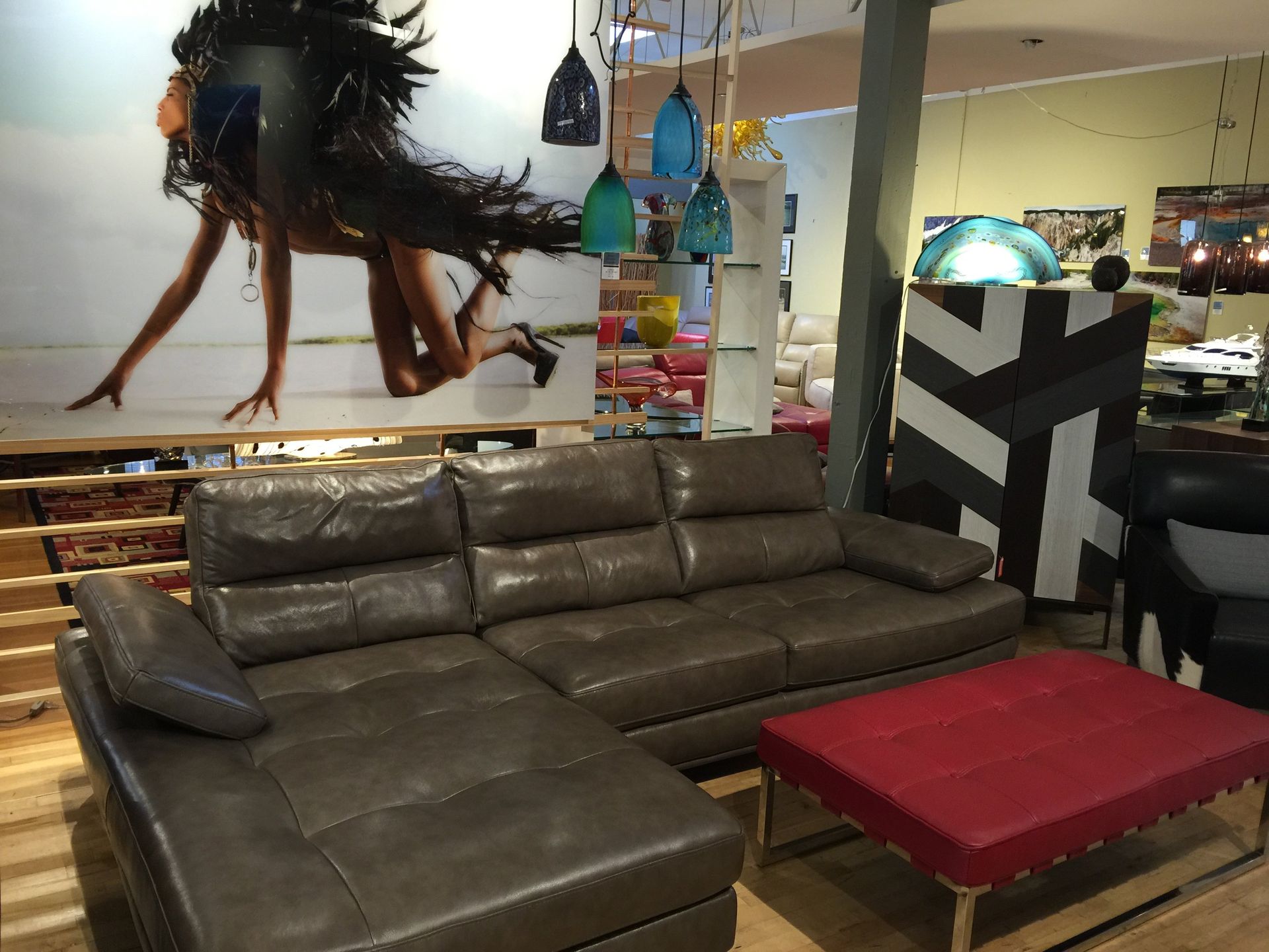 gray leather sectional and red ottoman