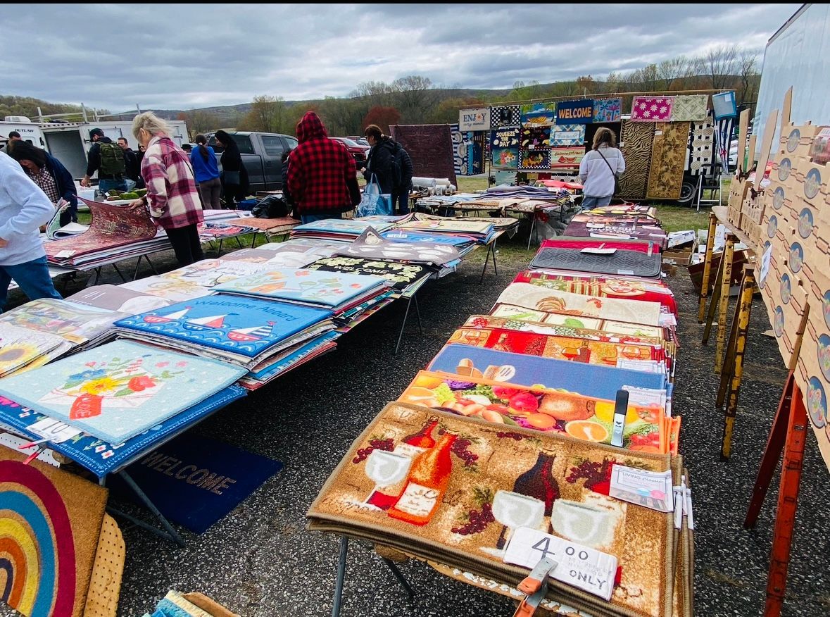 A group of people are standing around a table at a flea market.