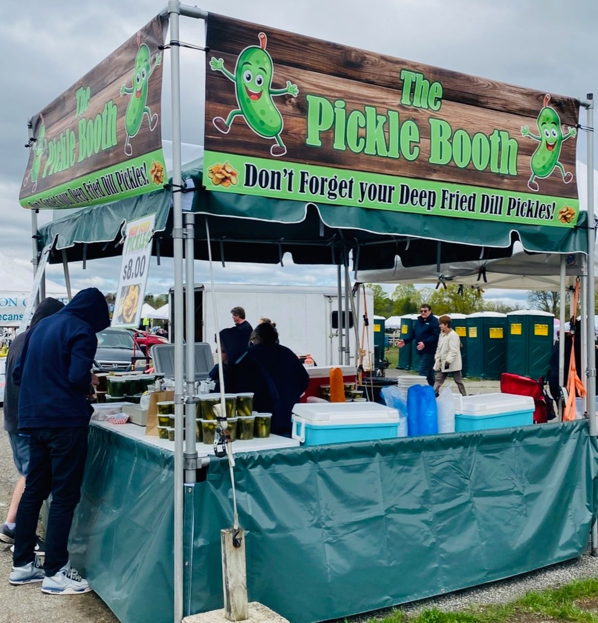 A pickle booth with people standing around it