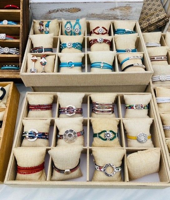 A variety of bracelets are displayed in boxes on a table