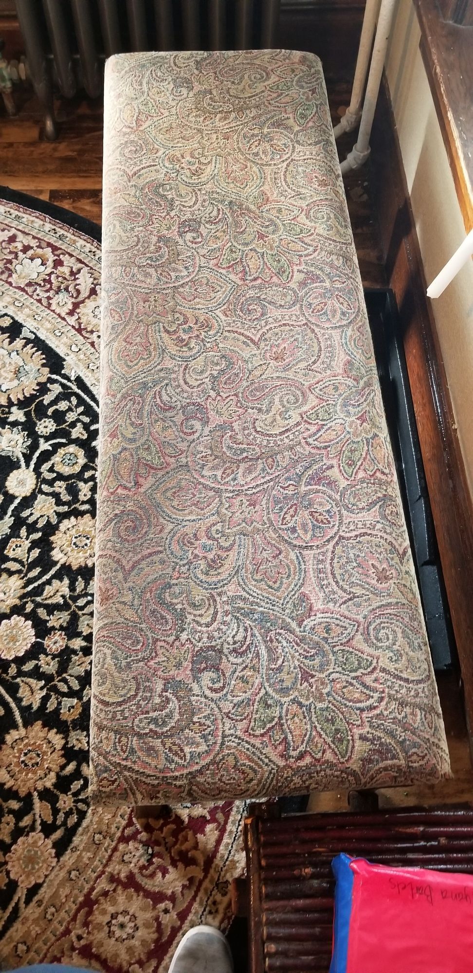 A long bench is sitting on top of a rug in a living room.
