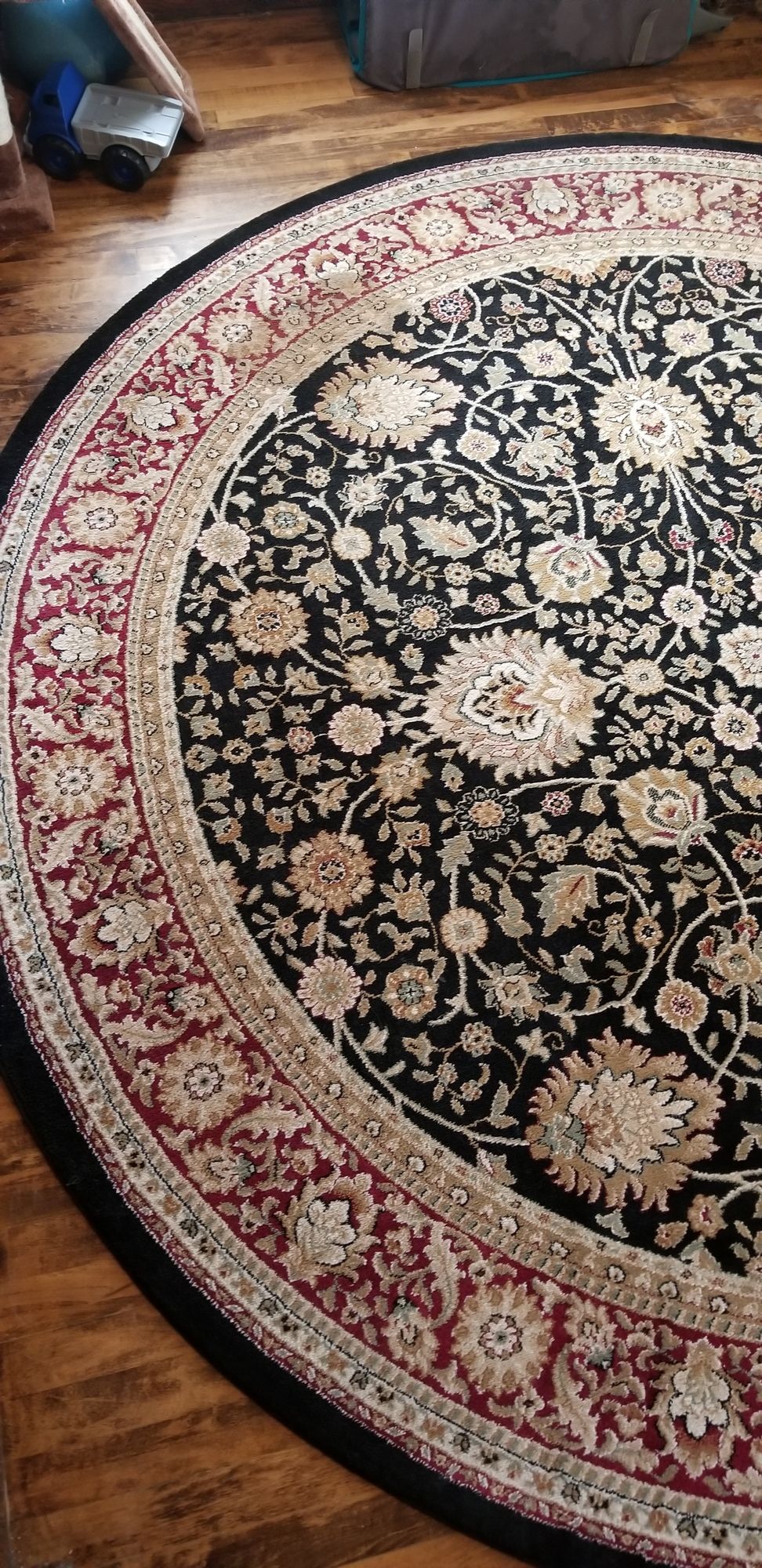 A round rug is sitting on a wooden floor.