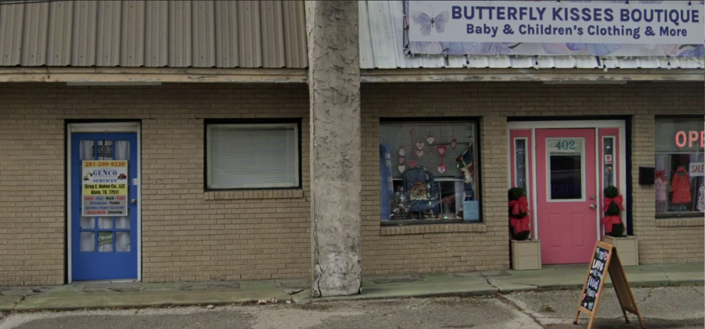 Exterior view of a brick building with a blue door and a pink door for 