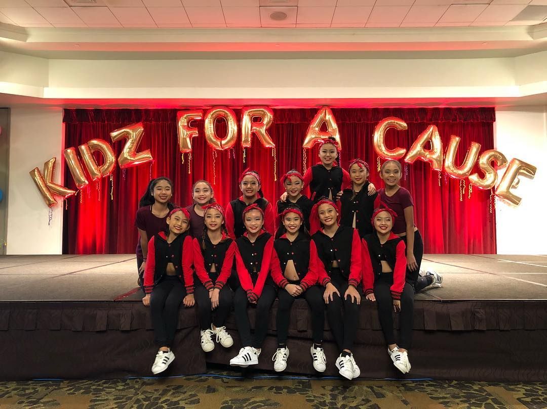 A group of young girls are posing for a picture on a stage.