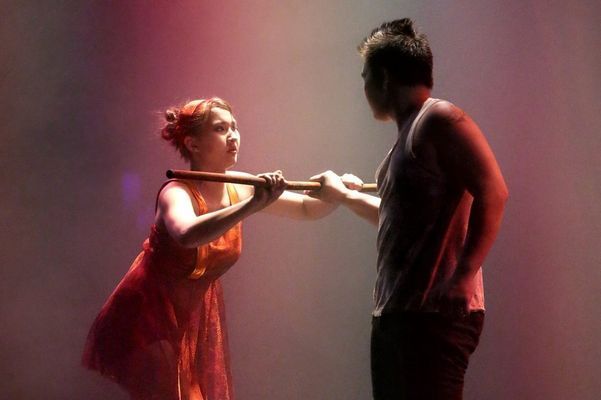 A man and a woman are holding hands in a dark room.
