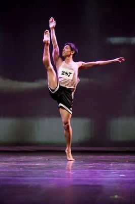 A man is doing a split on a stage.