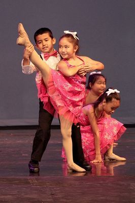 A group of young dancers are performing on a stage.