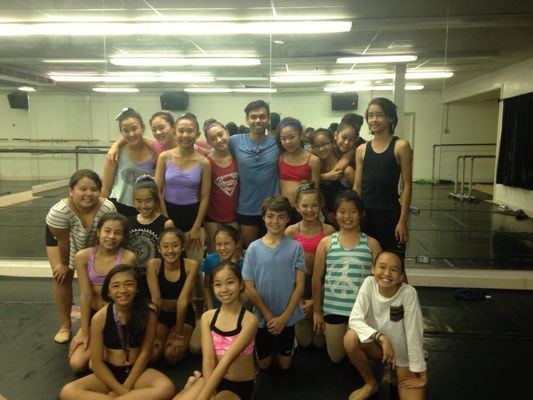 A group of young girls are posing for a picture in a dance studio