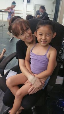 A woman is sitting in a chair with a little girl on her lap.