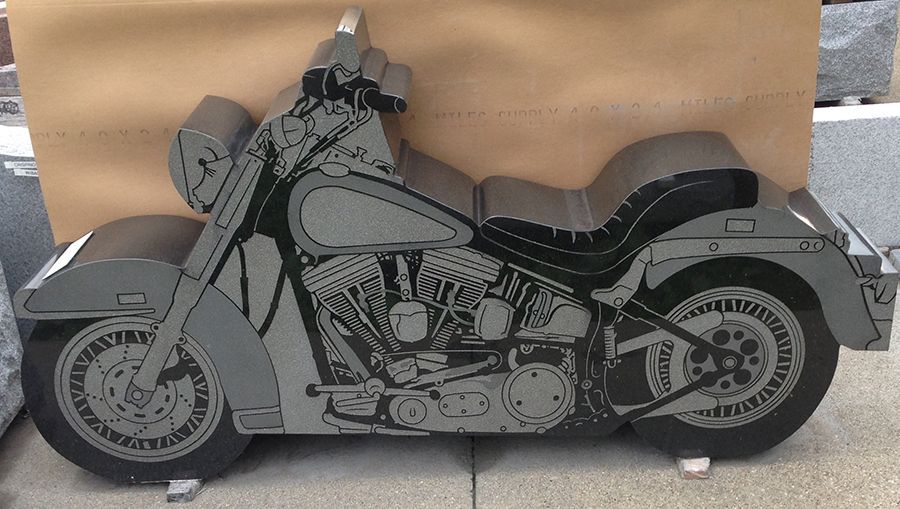Gray stone motorcycle silhouette carving.