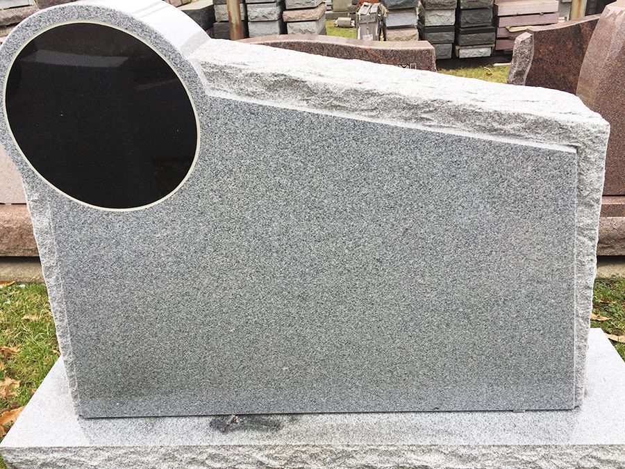 Gray granite headstone with a black oval inset.