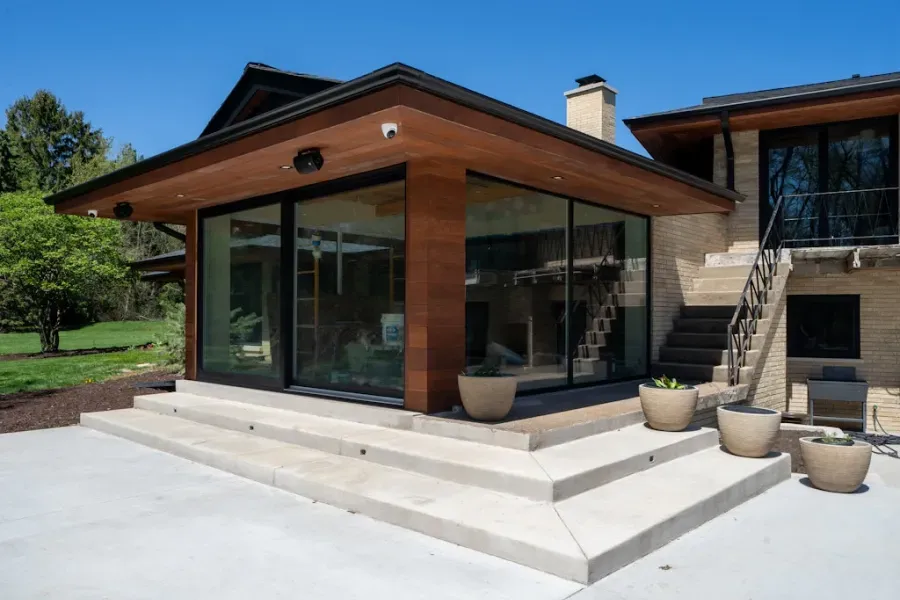 A large house with a patio and stairs in front of it.