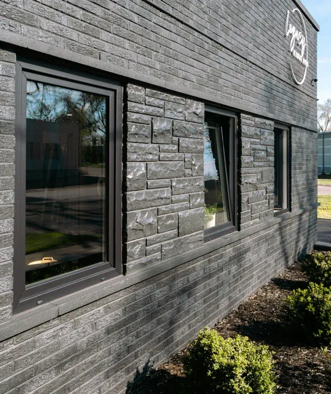 A black brick building with a lot of windows on it.