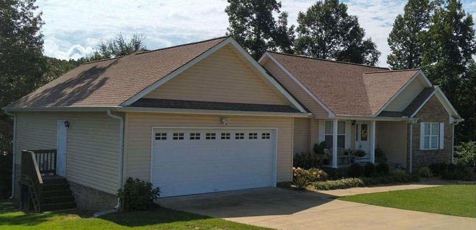 A house with a white garage door and a brown roof