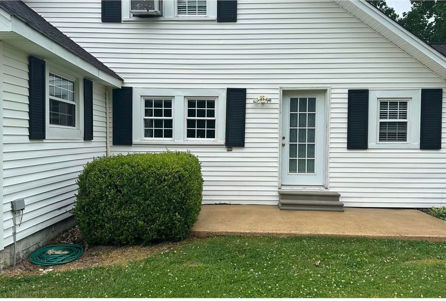 A white house with black shutters and a white door