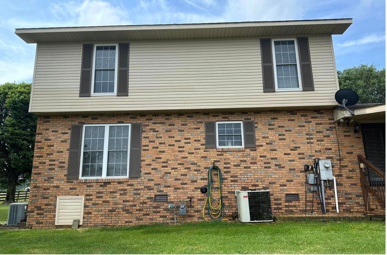 The back of a brick house with a lot of windows
