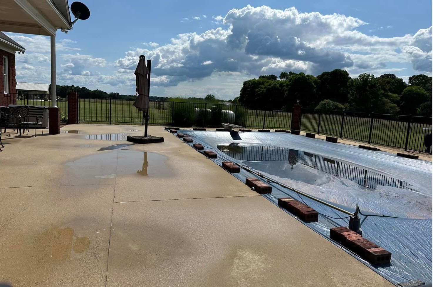 A large swimming pool with a house in the background