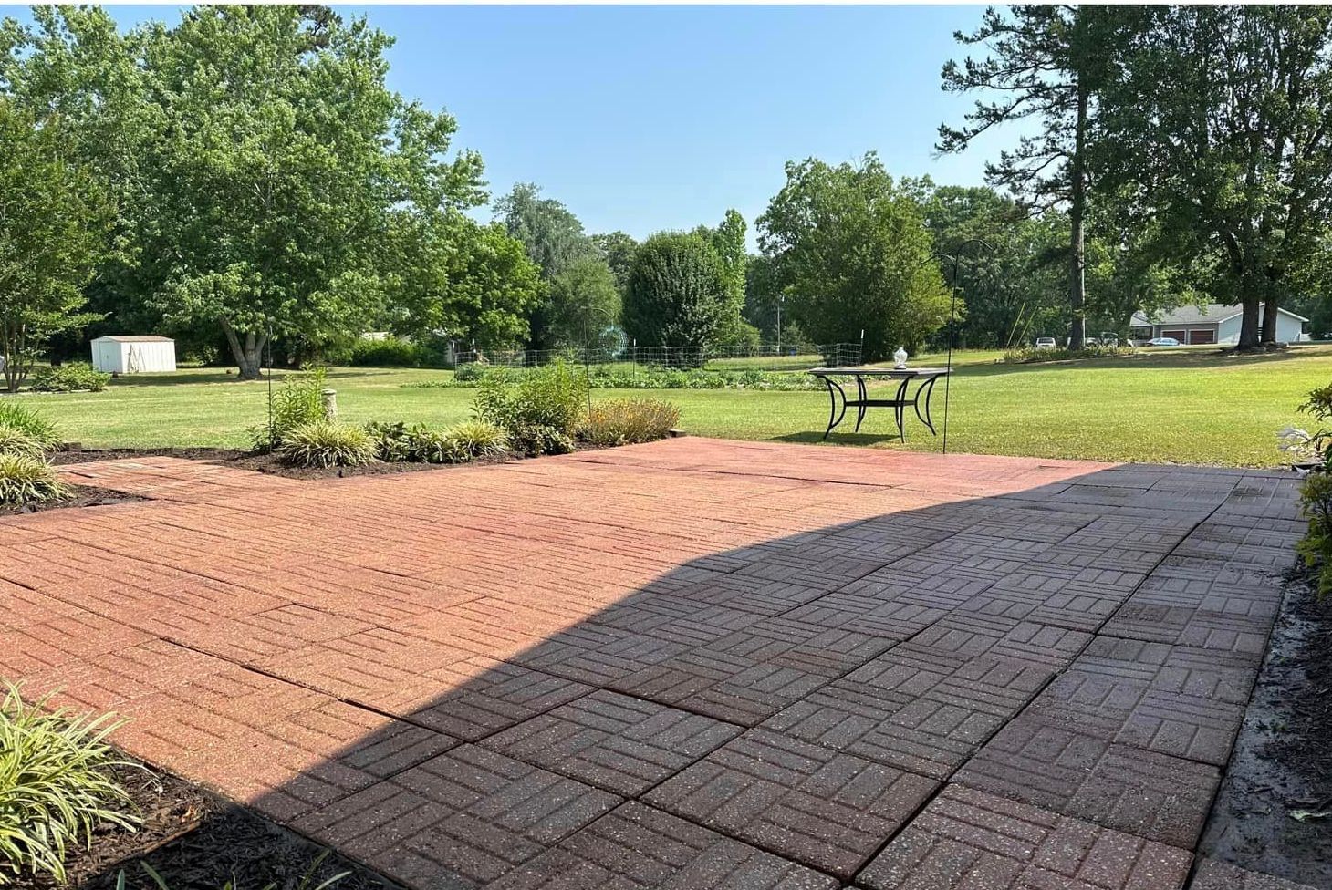 A brick patio with a picnic table in the background