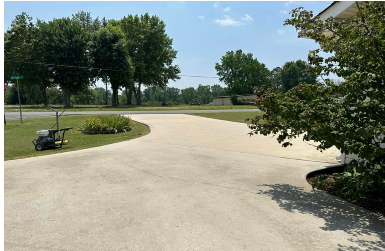 A driveway with a lawn mower in the middle of it