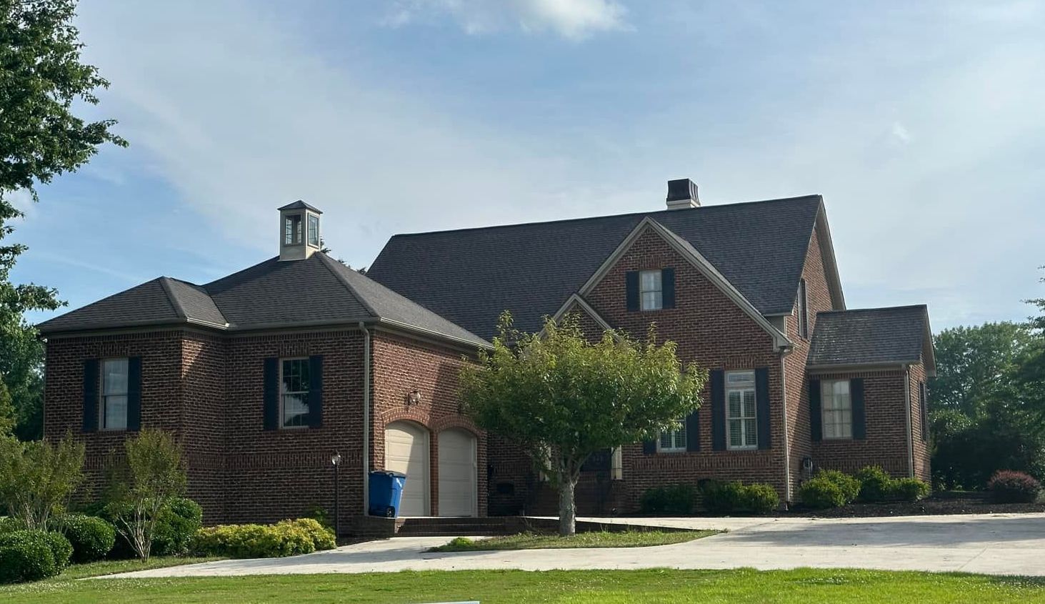 A large brick house with a black roof